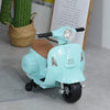 Mini Vespa électrique vert d'eau posée dans un intérieur, près d'un cactus dans un panier tressé